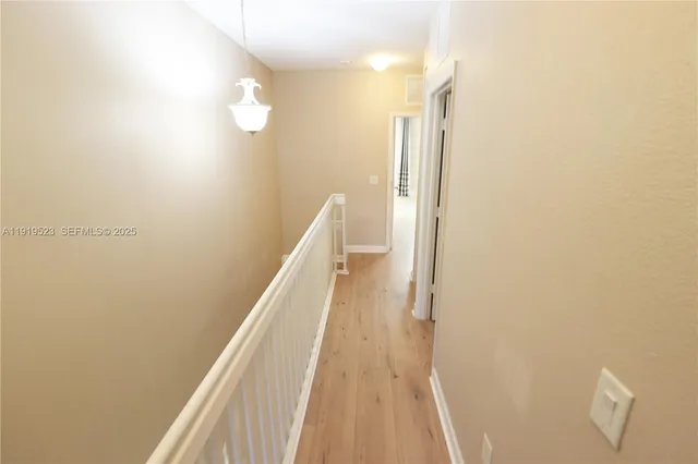 a view of a hallway with wooden floor and staircase