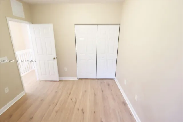 a view of a room with wooden floor and white walls