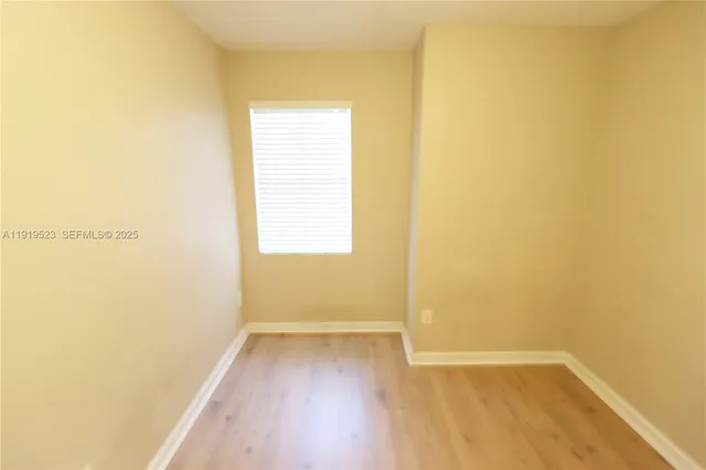 a view of a room with wooden floor and a window