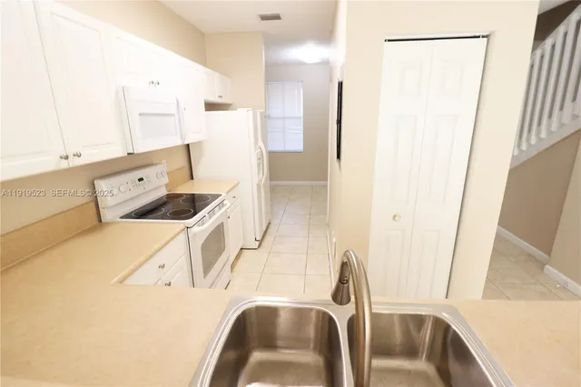 a view of a kitchen with stainless steel appliances wooden floor