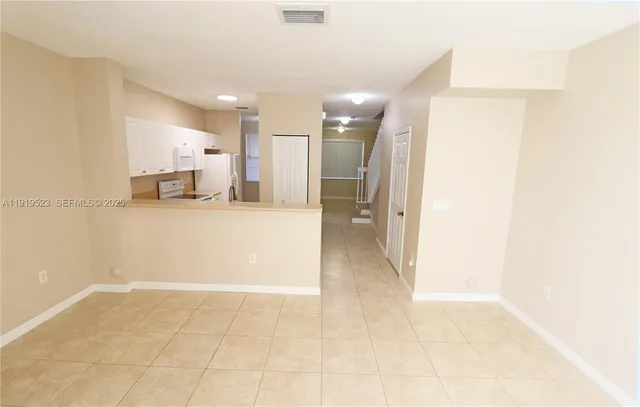 a view of a hallway to a kitchen