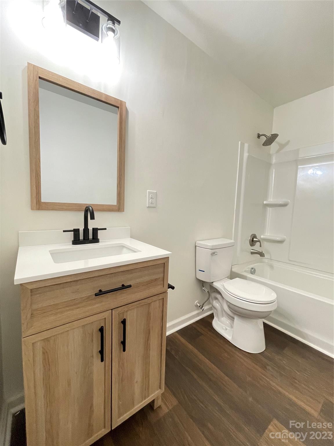 a bathroom with a toilet a sink a mirror and a bathtub