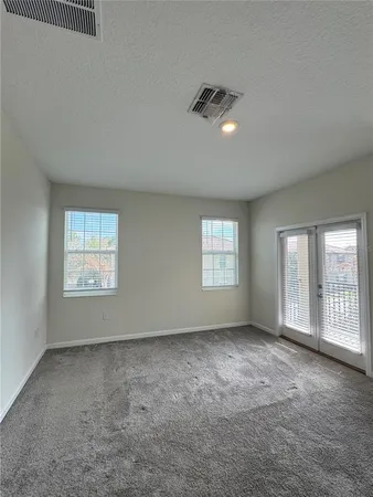 an empty room with windows and closet