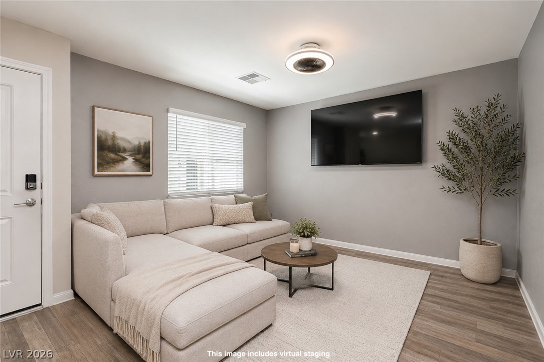 12369 Golden Wreath Road, Unit 2 Las Vegas, NV 89183 - Photo 6 of 19 Natural light filters into this inviting living area with warm wood flooring and a contemporary overhead fixture.