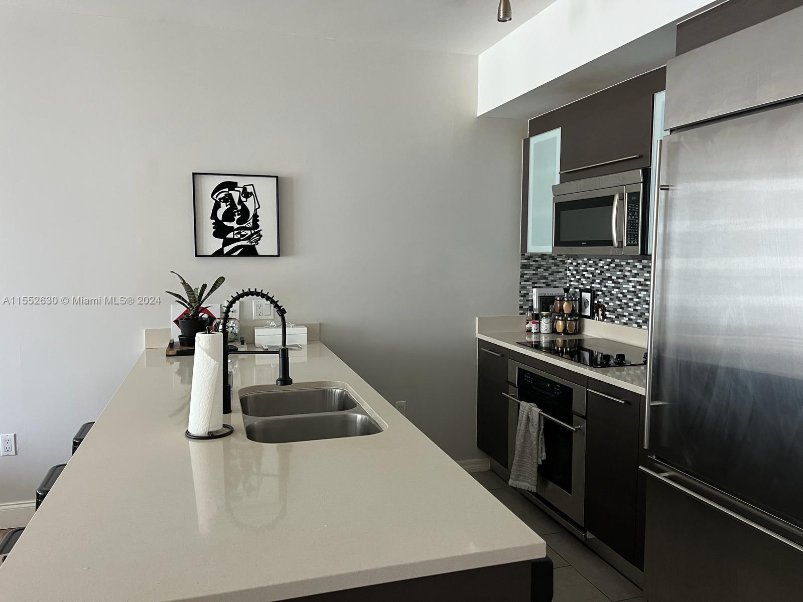 a kitchen with a sink and stainless steel appliances