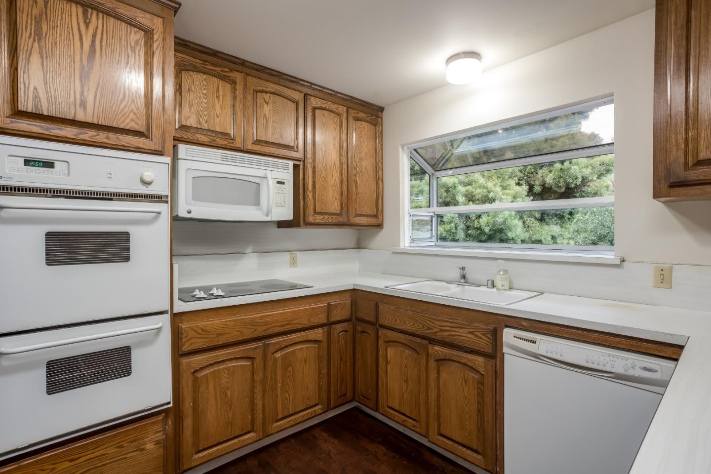 22381 McClellan Road Cupertino, CA 95014 - Photo 3 of 14 a kitchen with stainless steel appliances granite countertop white cabinets sink and window