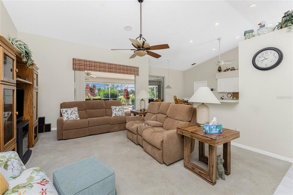 20 Long Meadow Place Rotonda West, FL 33947 - Photo 11 of 48 a living room with furniture a clock on a table and a chandelier
