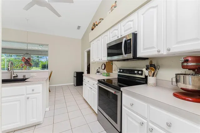 a kitchen with white cabinets and appliances