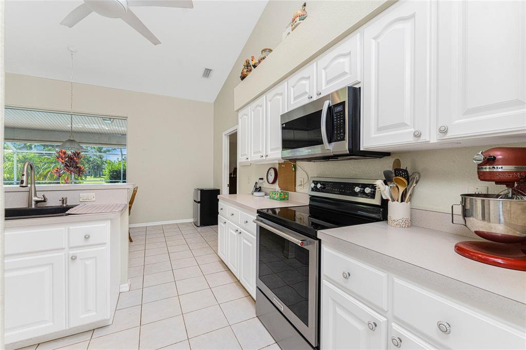 20 Long Meadow Place Rotonda West, FL 33947 - Photo 15 of 48 a kitchen with white cabinets and appliances