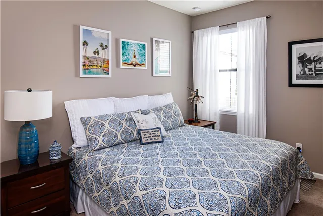 a bedroom with a bed and painting on the wall