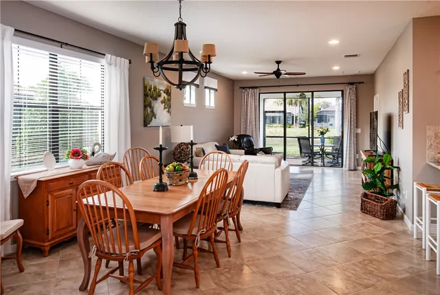 a dining room with furniture a chandelier and wooden floor