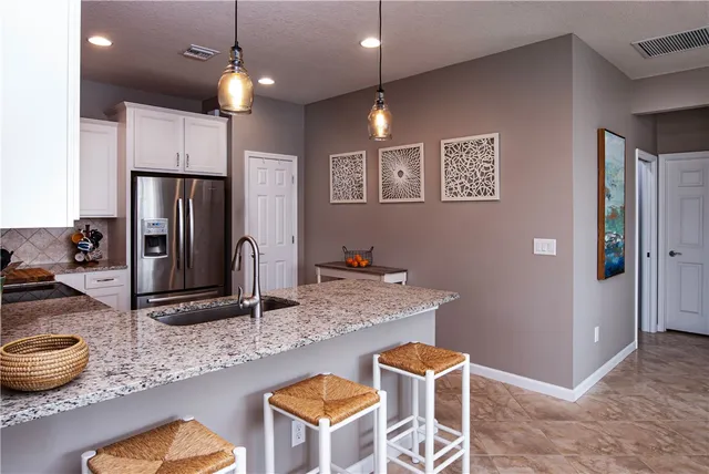 a kitchen with stainless steel appliances granite countertop a sink refrigerator and microwave