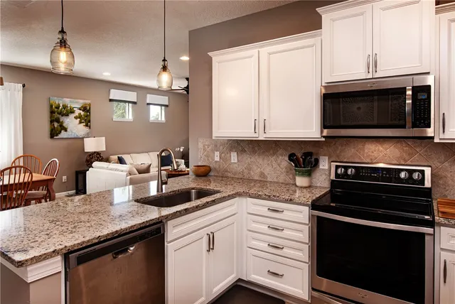 a kitchen with granite countertop a stove microwave and sink