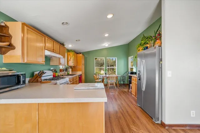 a kitchen with a refrigerator and a stove top oven