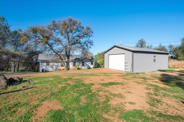 a view of backyard of house with trees
