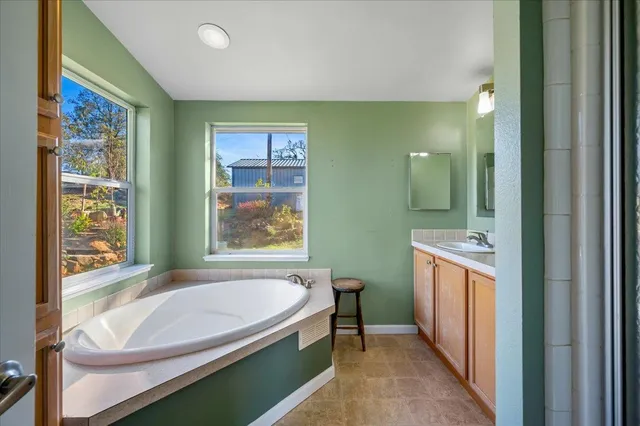 a bathroom with a granite countertop sink mirror and bathtub