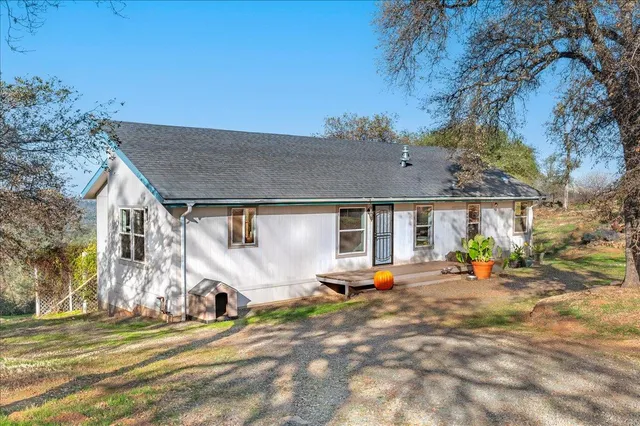 a view of a house with backyard and sitting area