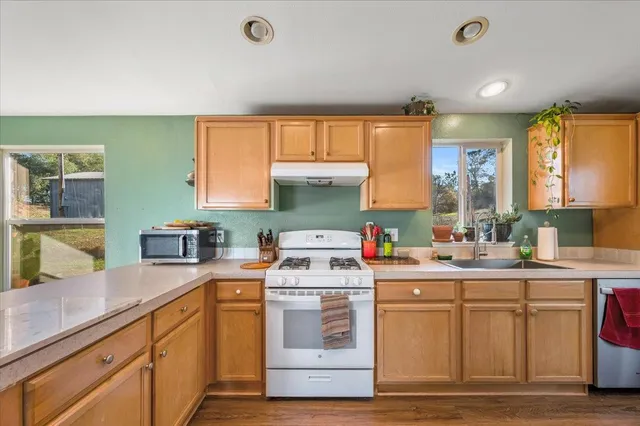 a large kitchen with a wooden floor and outdoor space