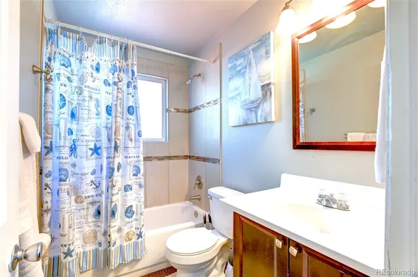 a bathroom with a sink a toilet and shower curtain