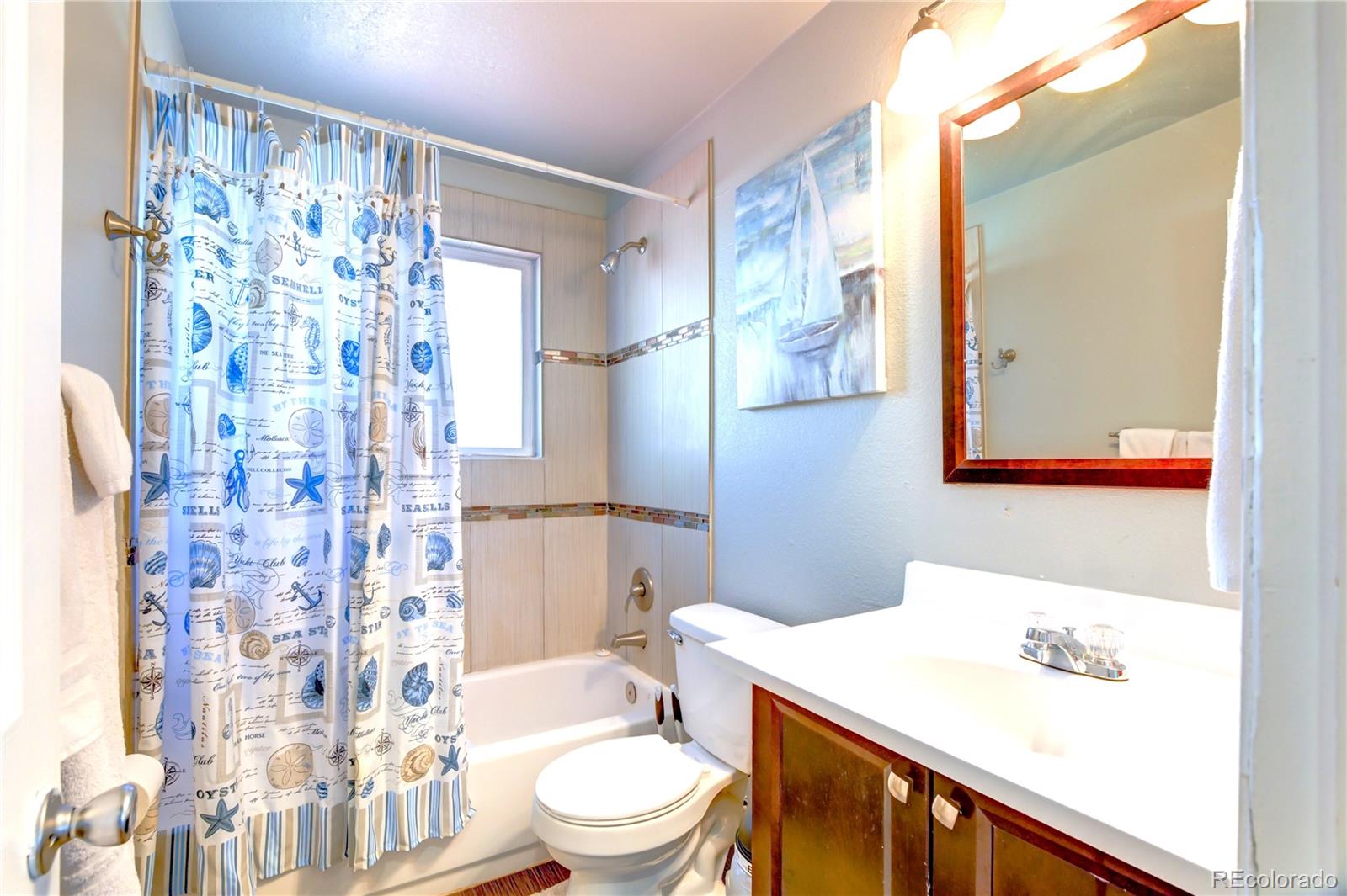 2361 West 57th Avenue Denver, CO 80221 - Photo 11 of 15 a bathroom with a sink a toilet and shower curtain