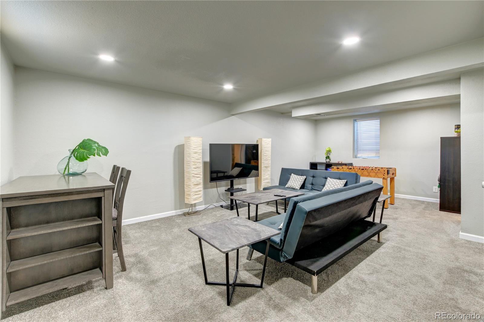 2361 West 57th Avenue Denver, CO 80221 - Photo 4 of 15 a living room with furniture and a flat screen tv