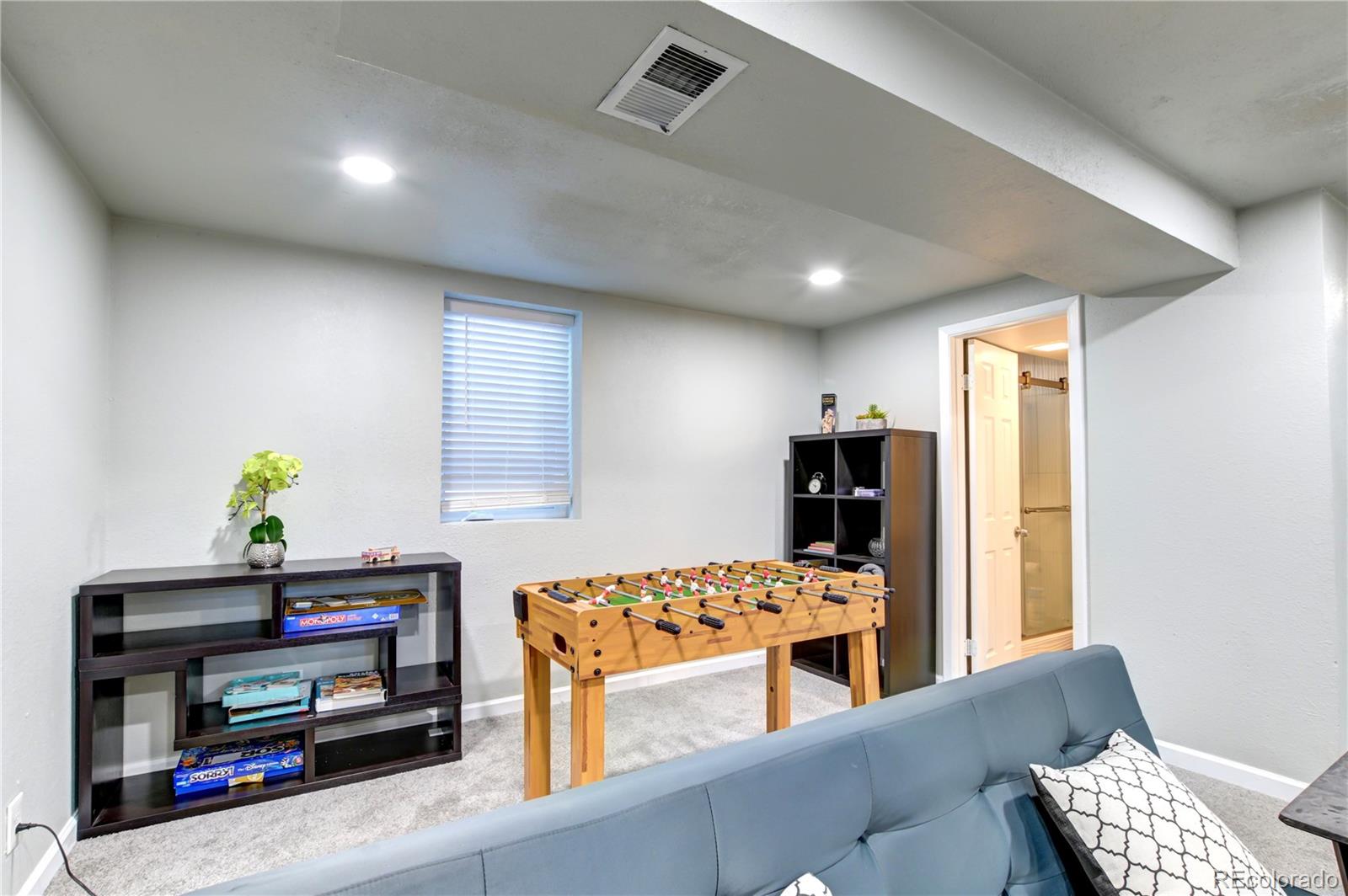 2361 West 57th Avenue Denver, CO 80221 - Photo 5 of 15 a living room with furniture and a flat screen tv