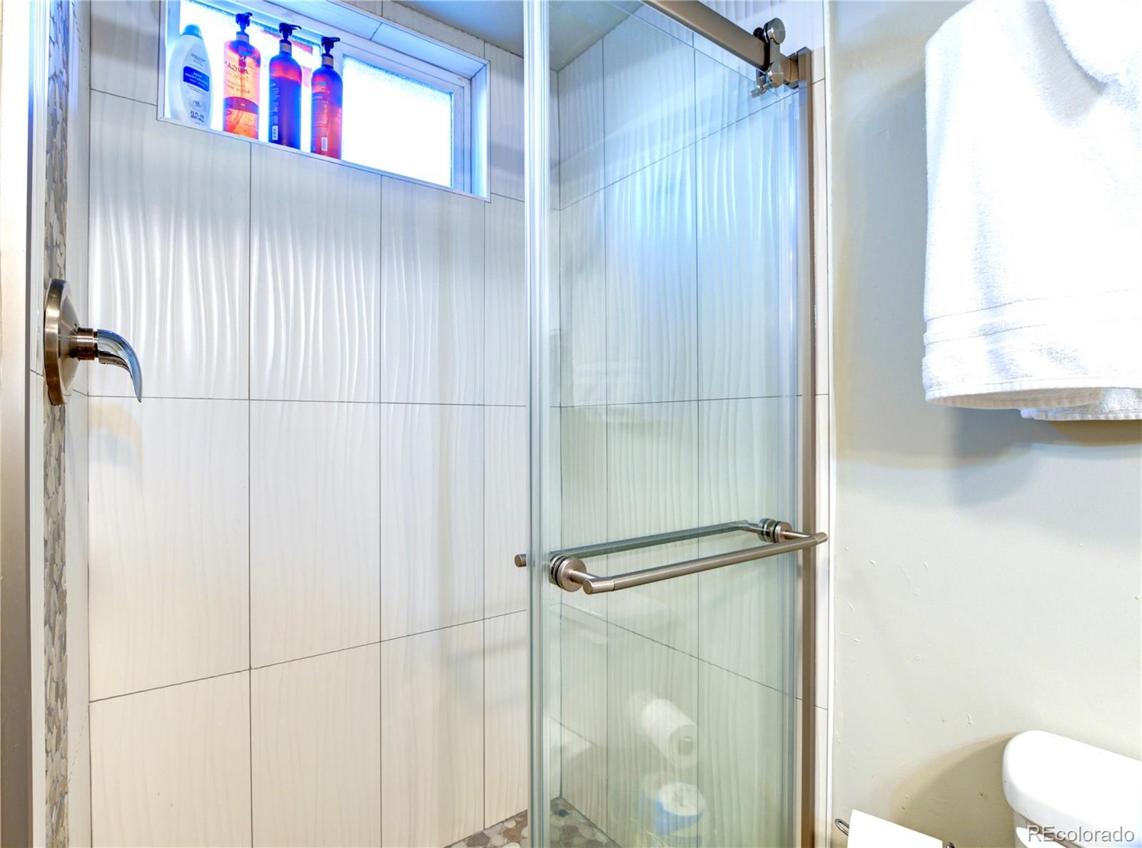 2361 West 57th Avenue Denver, CO 80221 - Photo 6 of 15 a bathroom with a window and a shower