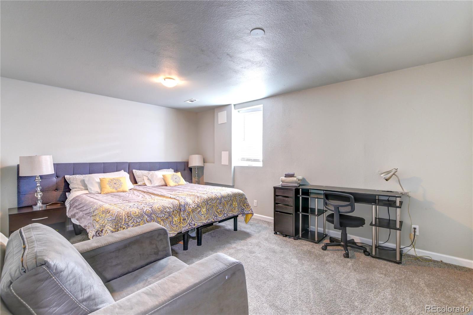 2361 West 57th Avenue Denver, CO 80221 - Photo 7 of 15 a bed room with a bed and a chair