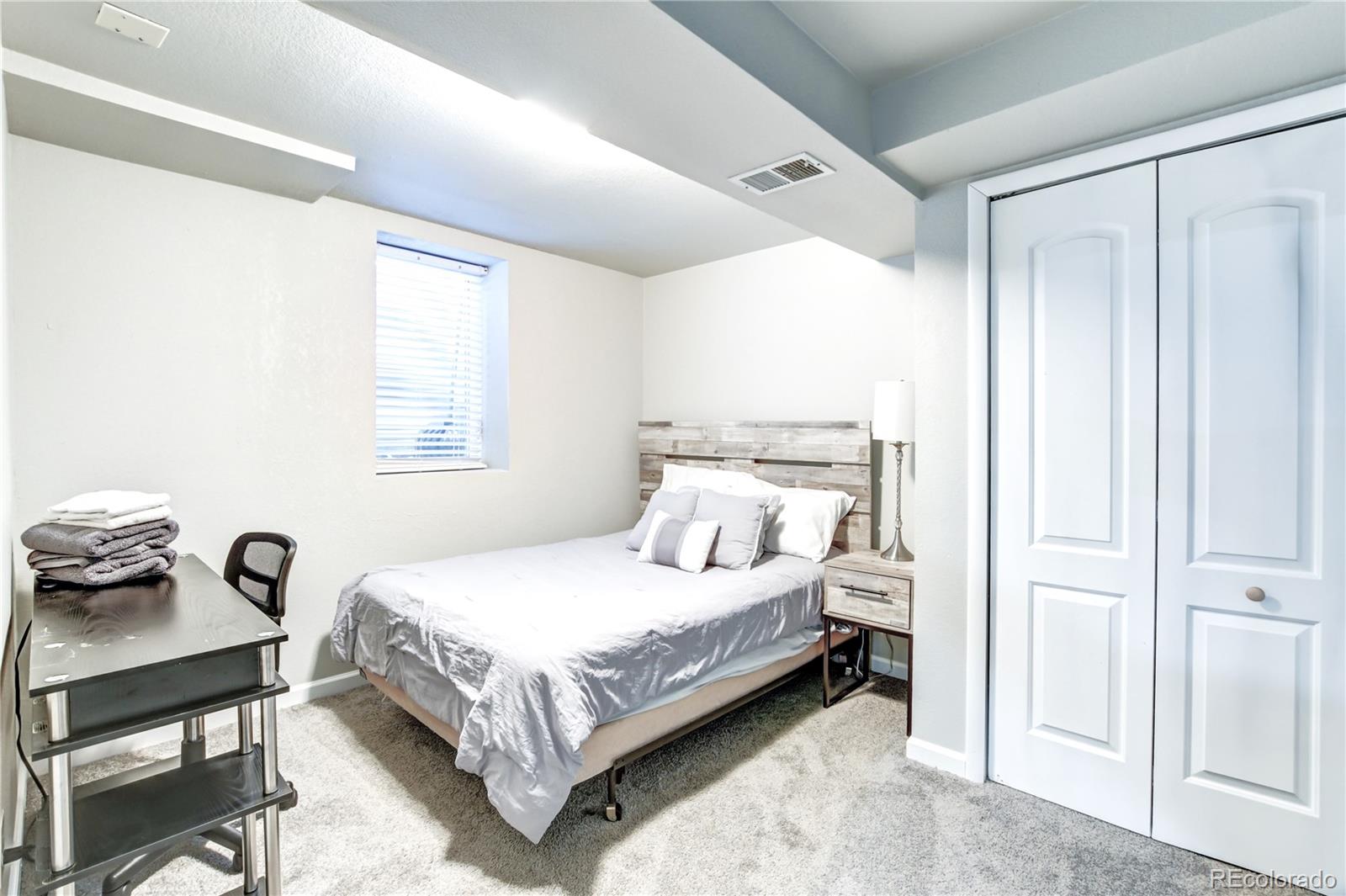 2361 West 57th Avenue Denver, CO 80221 - Photo 8 of 15 a bedroom with a bed and a window