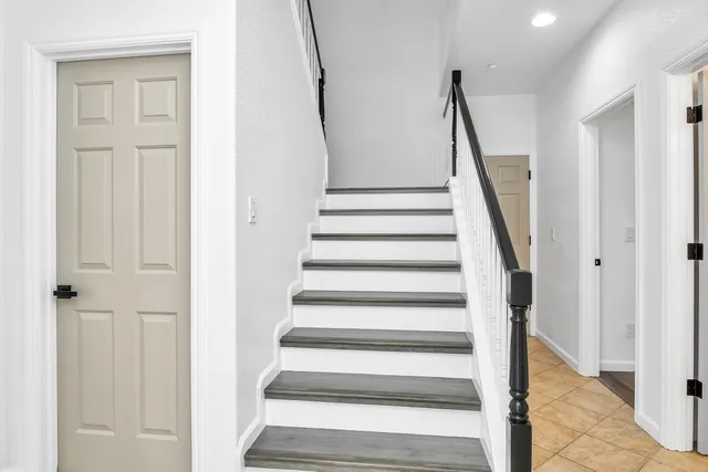 a view of staircase with wooden floor and white walls