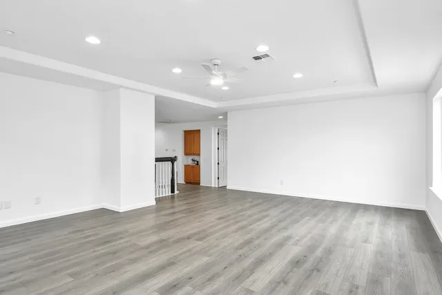 a view of an empty room with wooden floor