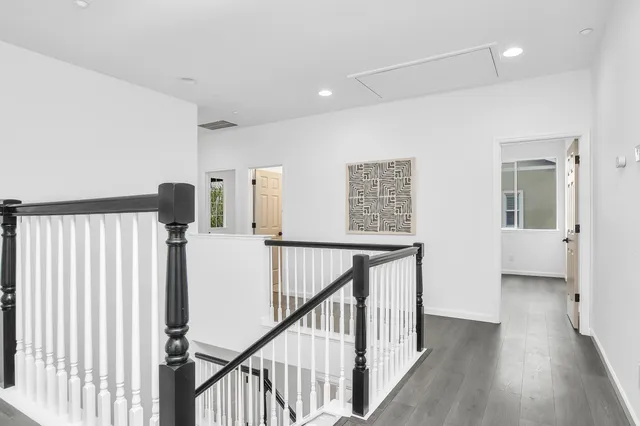 a view of a hallway with wooden floor and stairs