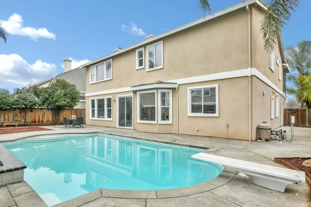 a view of a house with pool and sitting area