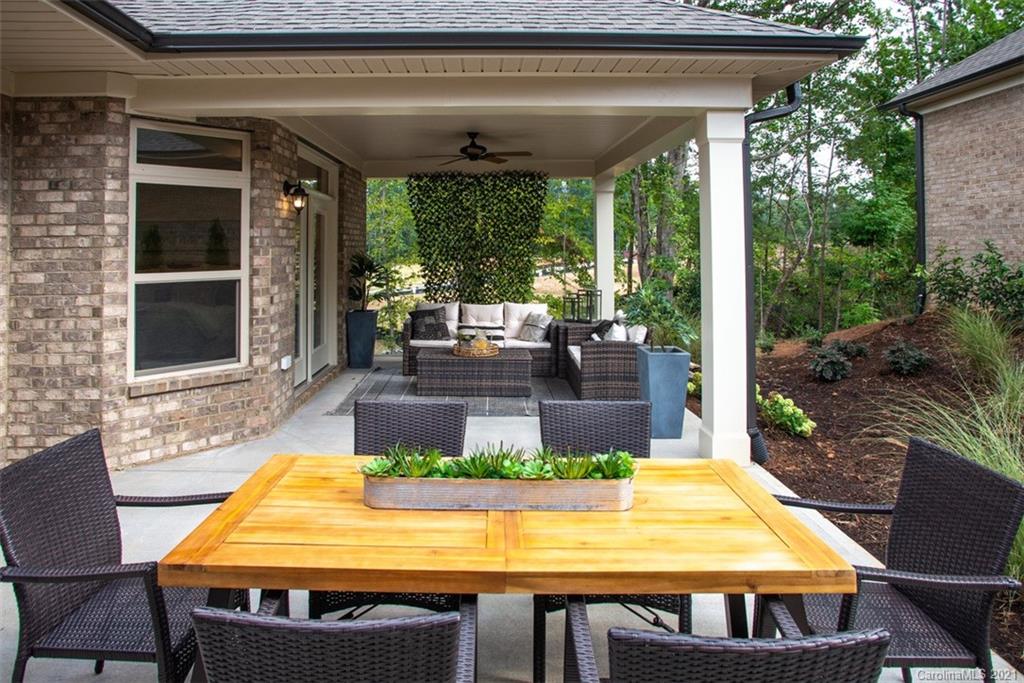 2064 New Style Way, Unit 40 Tega Cay, SC 29708 - Photo 6 of 16 a view of a patio with table and chairs potted plants with wooden floor