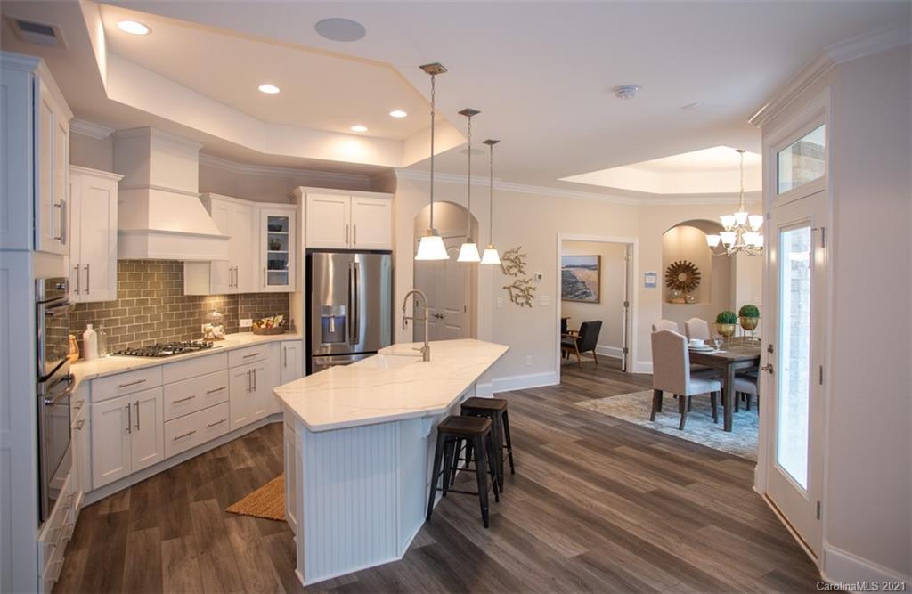 2064 New Style Way, Unit 40 Tega Cay, SC 29708 - Photo 8 of 16 a large kitchen with cabinets chairs and wooden floor