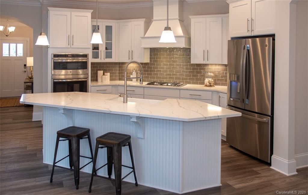 2064 New Style Way, Unit 40 Tega Cay, SC 29708 - Photo 9 of 16 a kitchen with refrigerator a sink and chairs