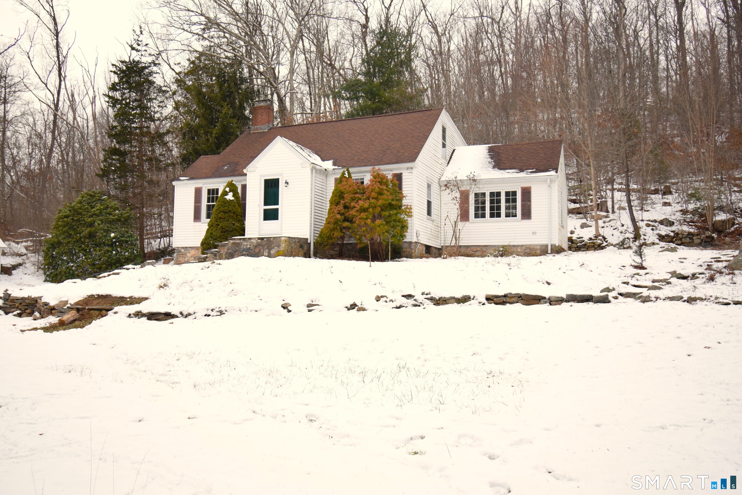 a view of a white house with a yard covered in snow