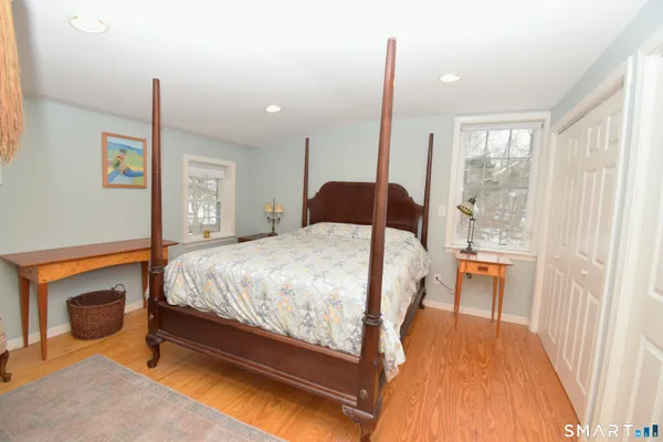 a bedroom with a bed and wooden floor