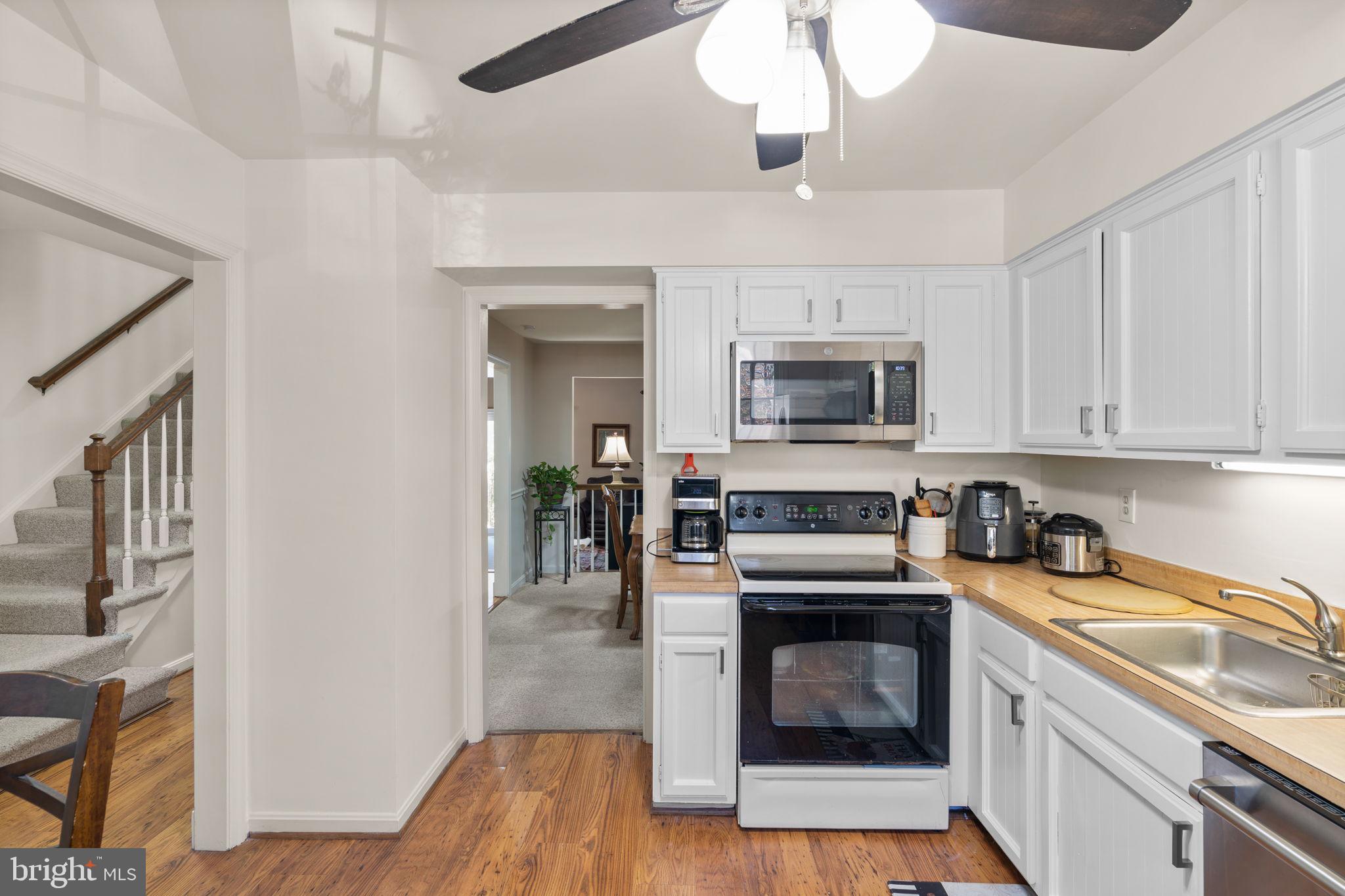 1043 Windrush Lane, Unit 5 Sandy Spring, MD 20860 - Photo 12 of 28 a kitchen with granite countertop a stove top oven a sink and a microwave oven