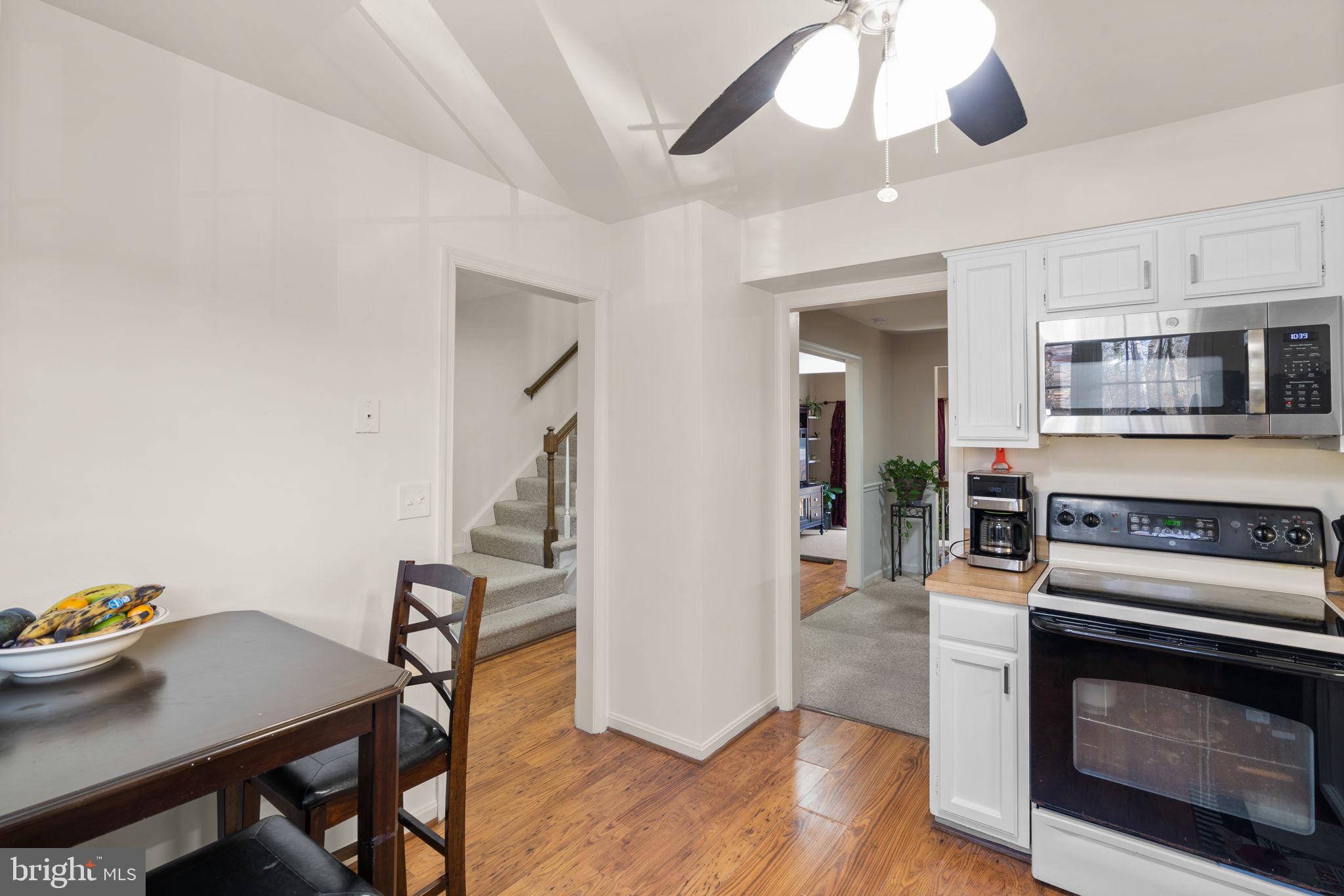 1043 Windrush Lane, Unit 5 Sandy Spring, MD 20860 - Photo 14 of 28 a kitchen with stainless steel appliances kitchen island granite countertop a stove and a wooden floor
