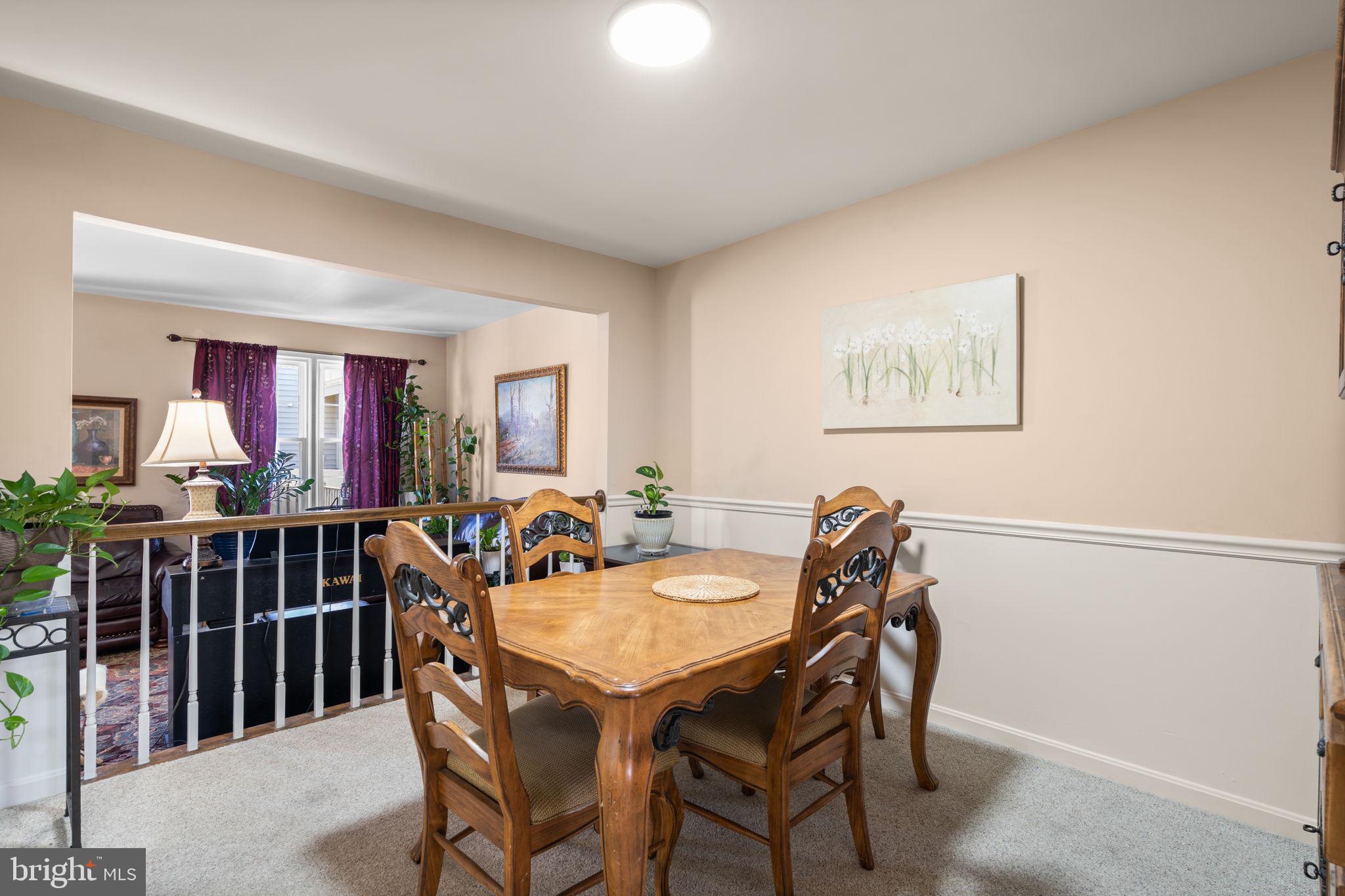 1043 Windrush Lane, Unit 5 Sandy Spring, MD 20860 - Photo 7 of 28 a view of a dining room and livingroom with furniture wooden floor a rug a painting and a chandelier