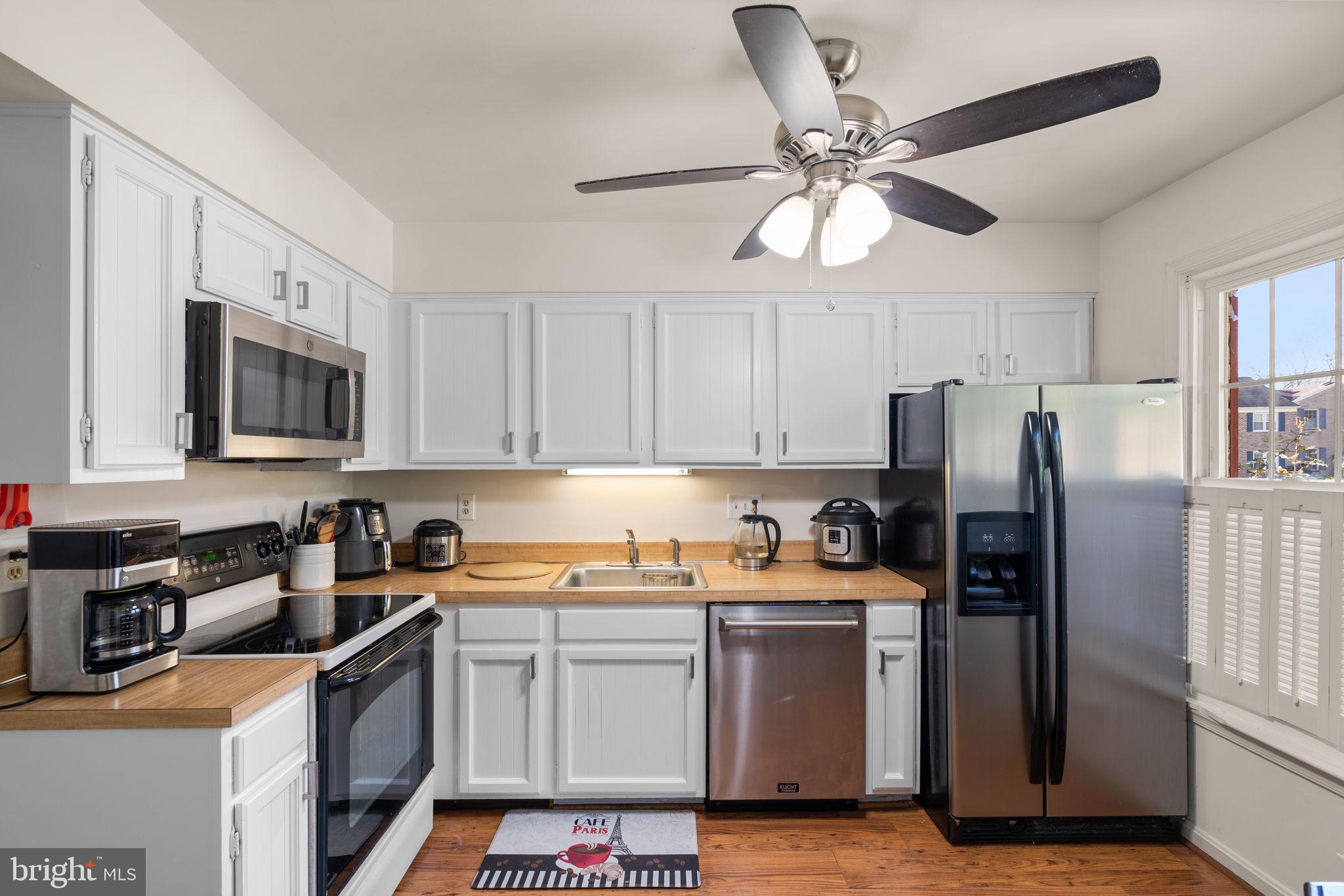 1043 Windrush Lane, Unit 5 Sandy Spring, MD 20860 - Photo 9 of 28 a kitchen with stainless steel appliances granite countertop a refrigerator a sink a stove a microwave oven with white cabinets