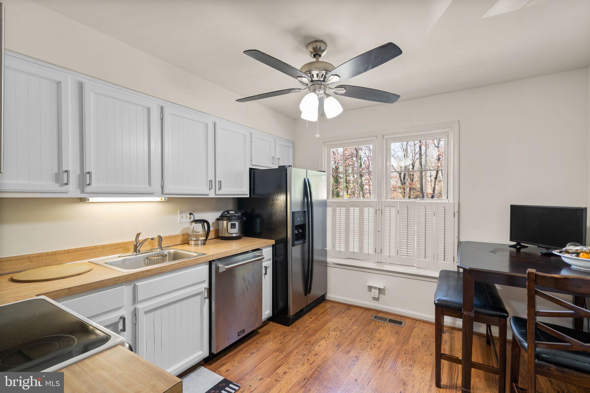 1043 Windrush Lane, Unit 5 Sandy Spring, MD 20860 - Photo 10 of 28 a kitchen with a refrigerator cabinets and wooden floor