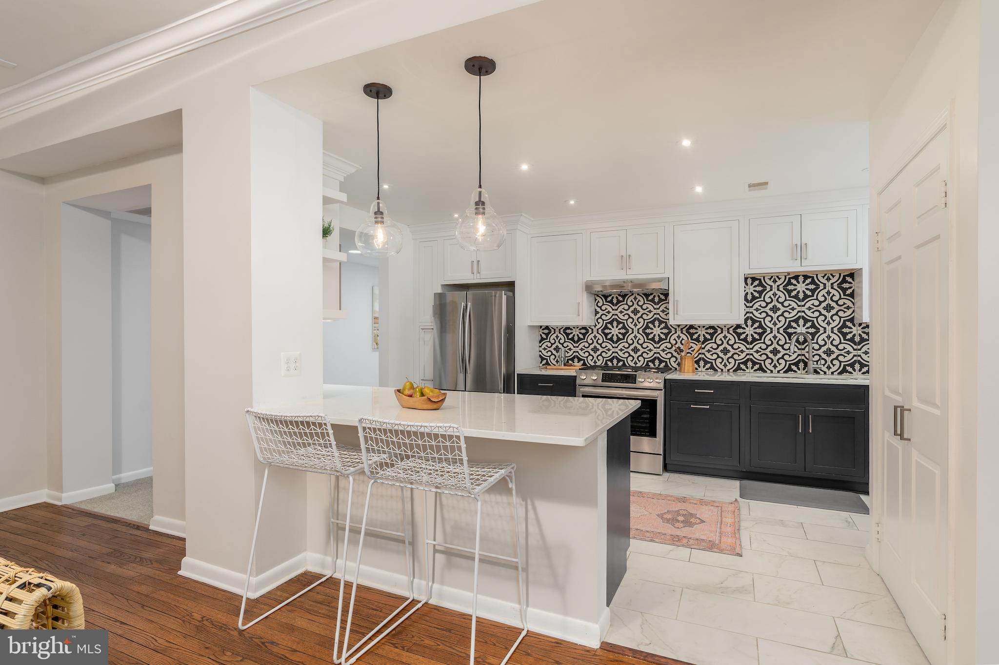 2230 California Street Northwest, Unit 3BE Washington, DC 20008 - Photo 22 of 49 a kitchen with stainless steel appliances kitchen island granite countertop a table and chairs in it