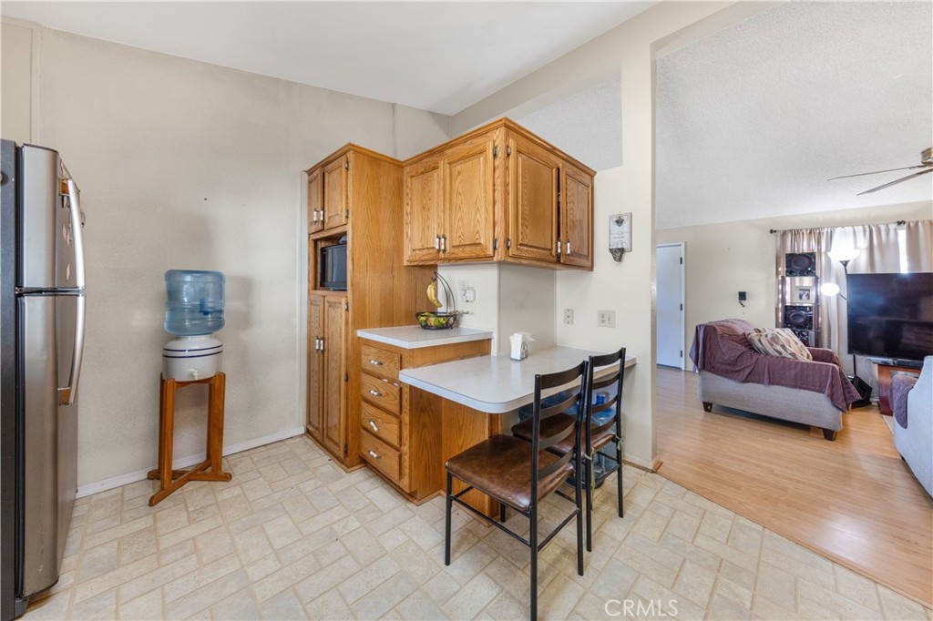602 Roadrunner Way Perris, CA 92570 - Photo 12 of 27 a living room with furniture a flat screen tv and a refrigerator
