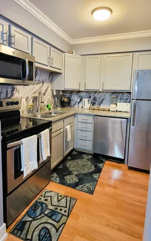a kitchen with stainless steel appliances granite countertop a stove a sink and a refrigerator