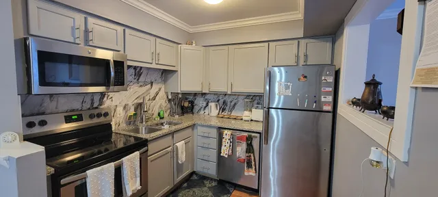 a kitchen with a refrigerator stove and cabinets