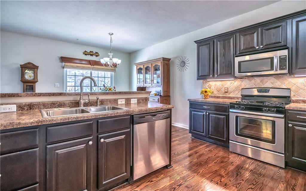 152 Harmony Road Wexford, PA 15090 - Photo 8 of 25 The kitchen features stainless appliances, a tile backsplash, under cabinet lights, pantry, seating at the kitchen island & access to the garage.