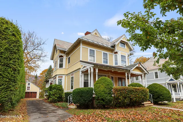 a front view of a residential houses with yard