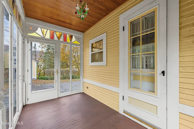 a view of a hallway with wooden floor and stairs